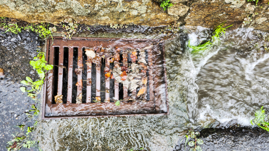 Water is flowing down a residential street's storm drain 