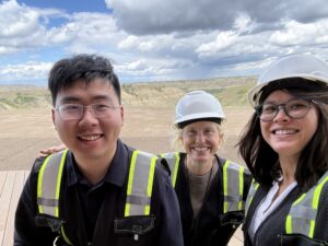 Three people in reflective gear and hard hats