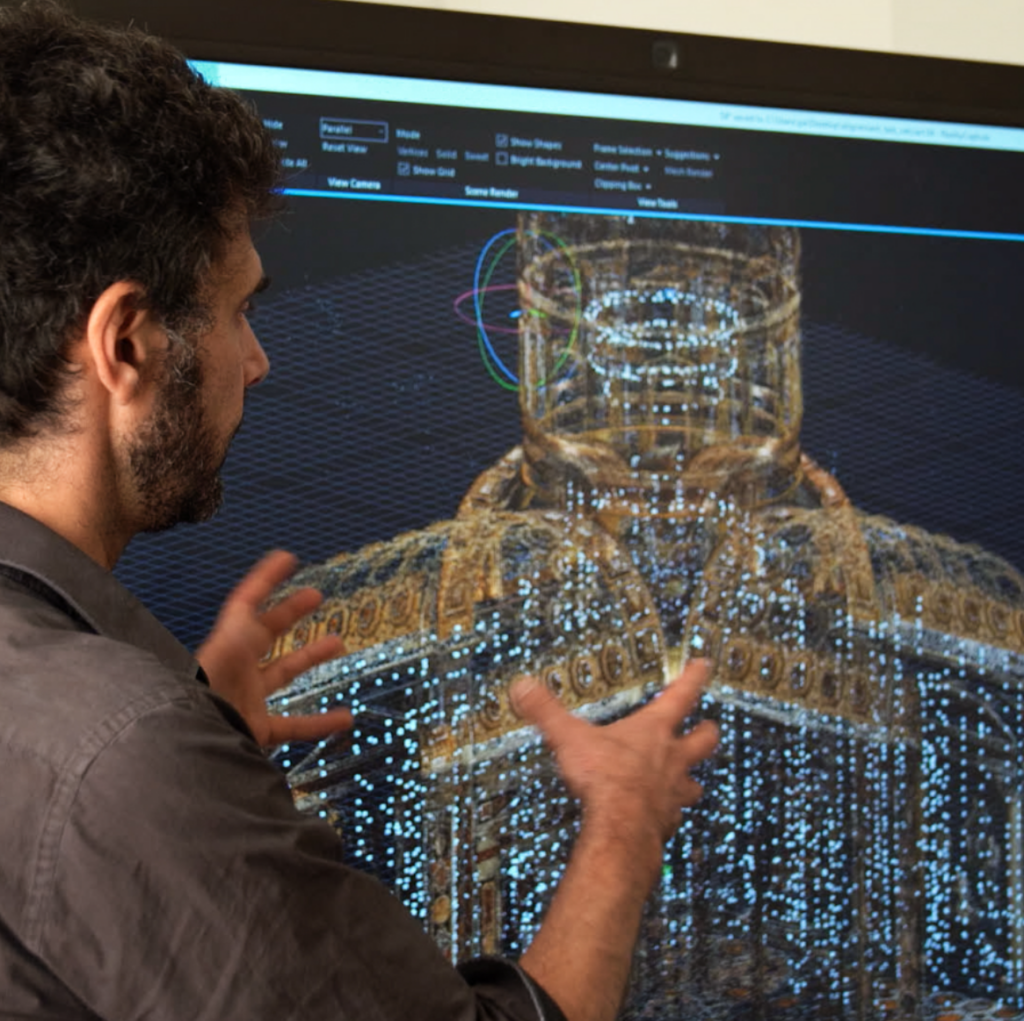 a man in front of a large monitor displaying parts of a digitally re-created vatican
