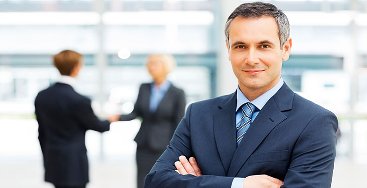 a man wearing a suit and tie smiling at the camera
