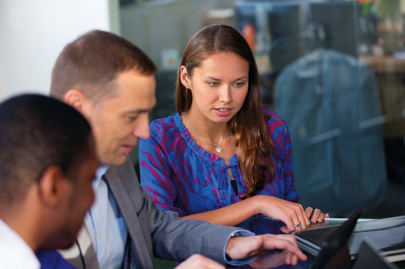 a group of people looking at a laptop