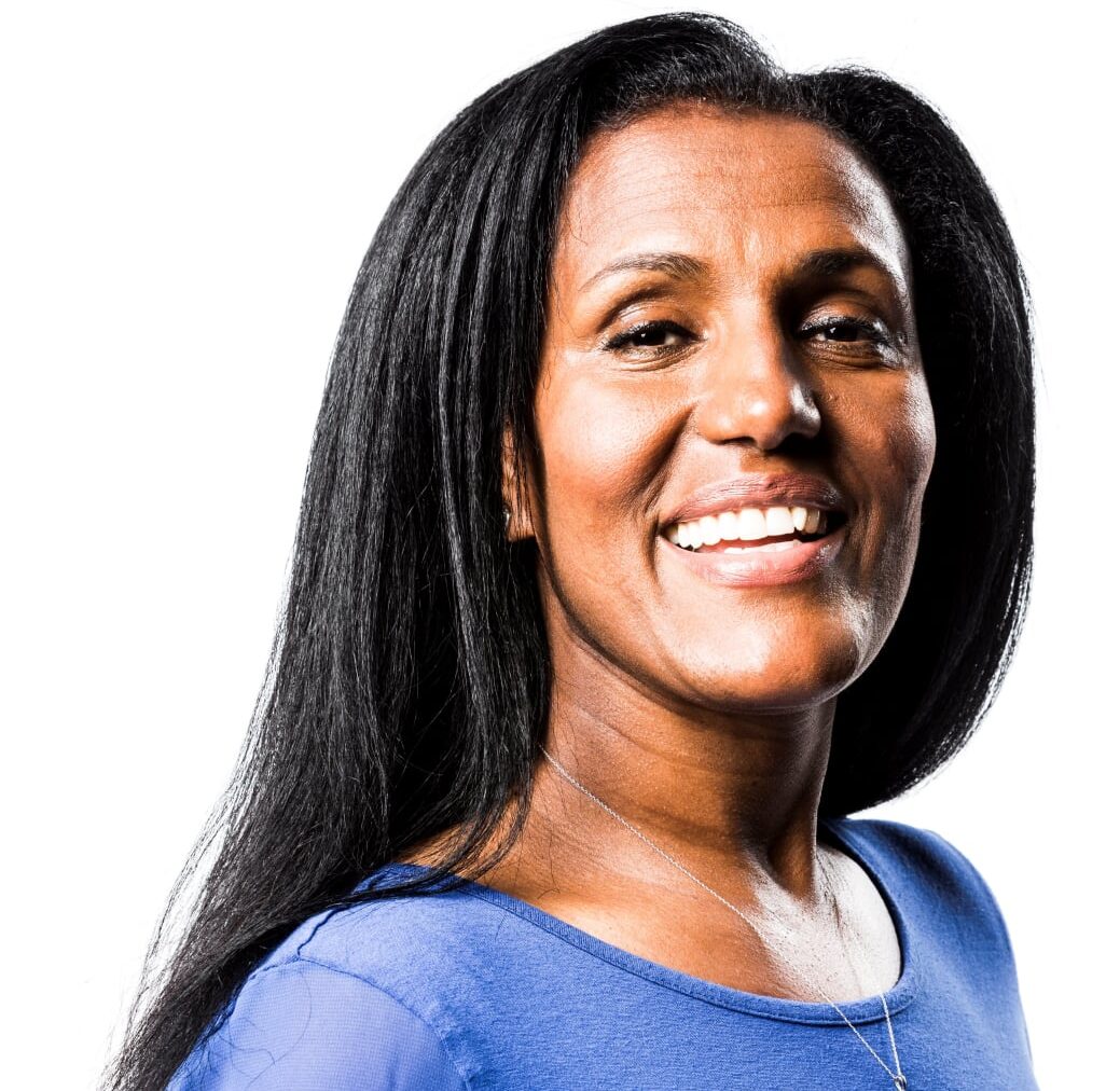 a woman in a blue shirt and smiling at the camera