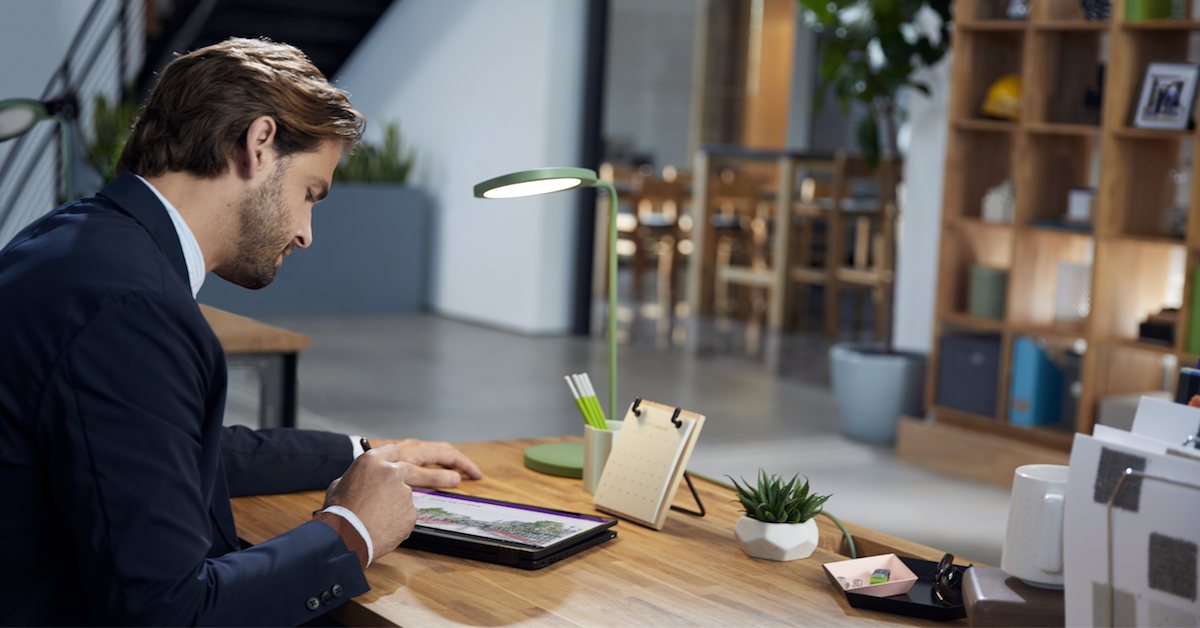 a person sitting at a table using a laptop