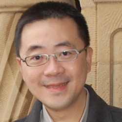 a man wearing glasses and smiling at the camera