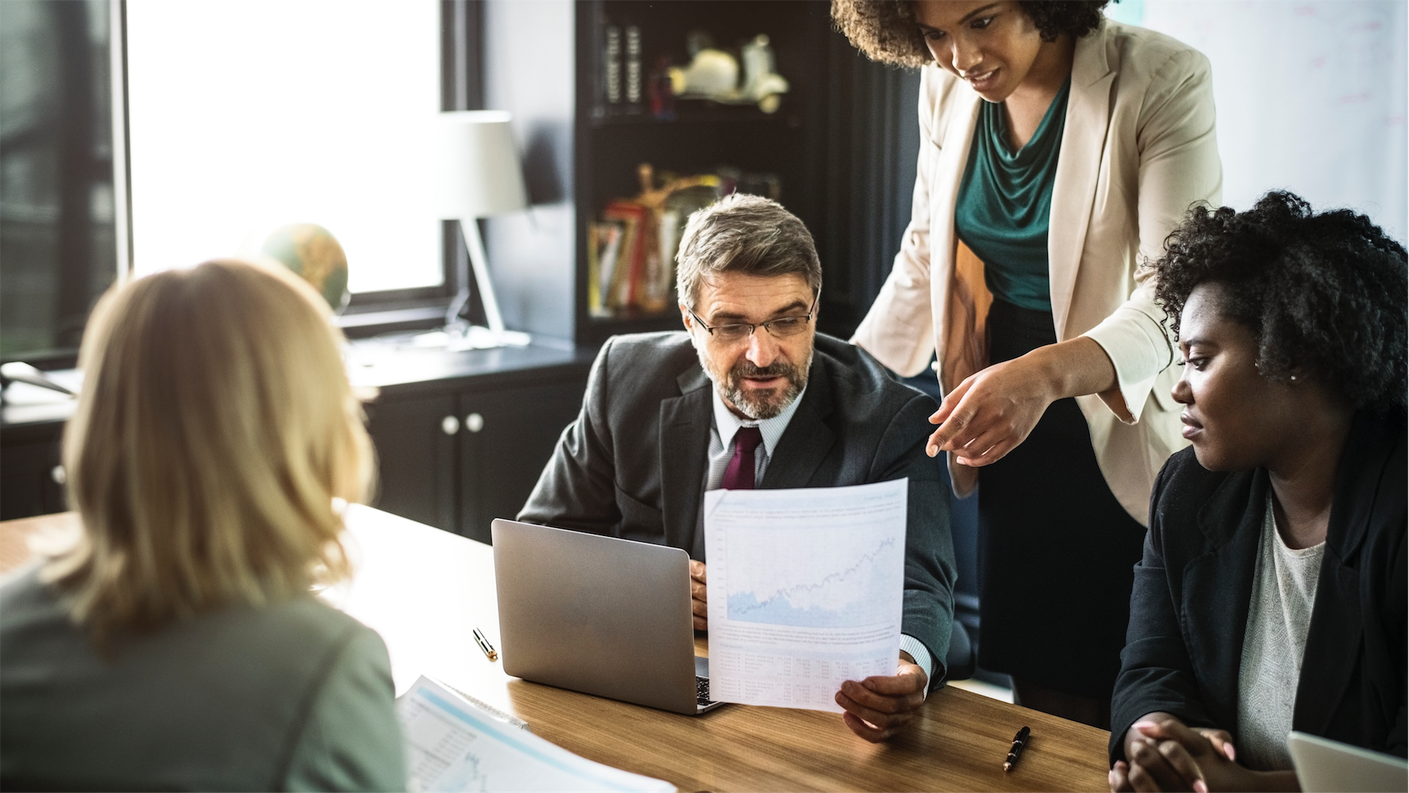 a group of people standing around a table