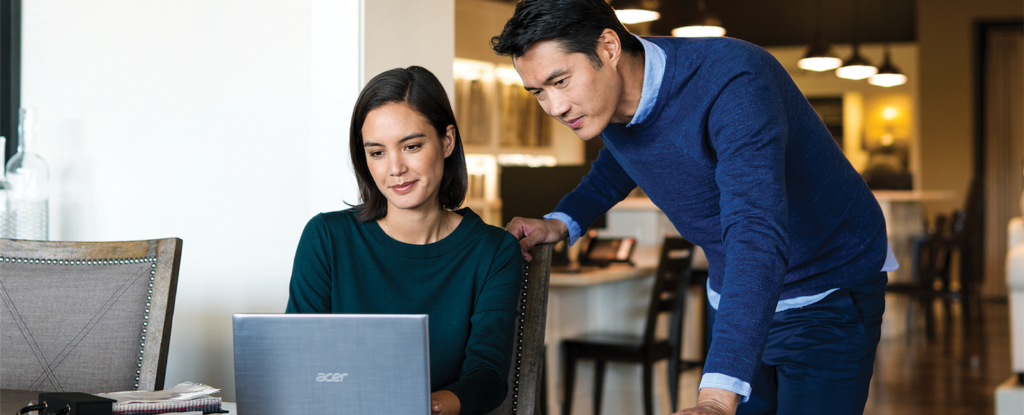 a group of people sitting at a table using a laptop