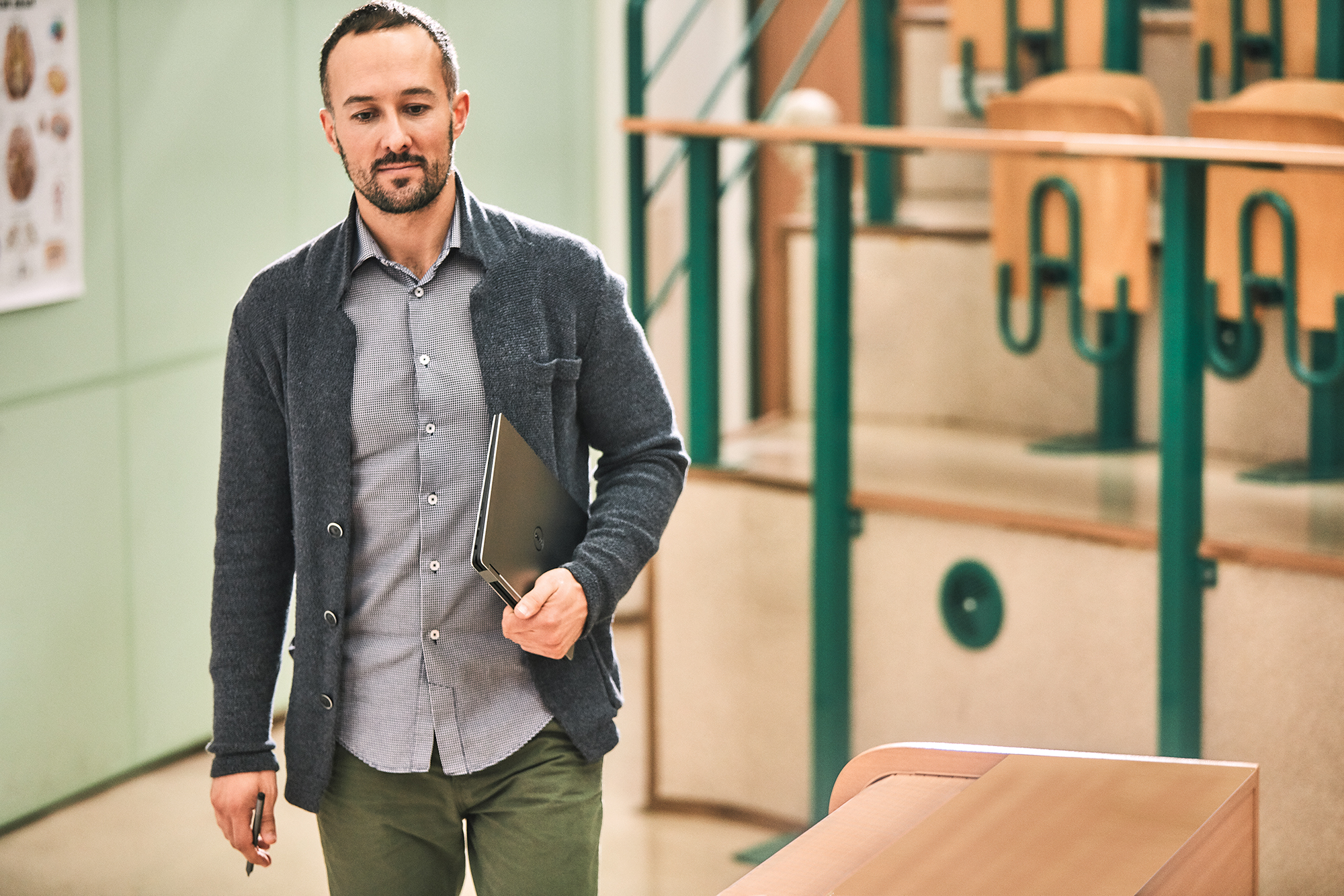 Man walking indoors with Dell XPS 13 laptop in tote.