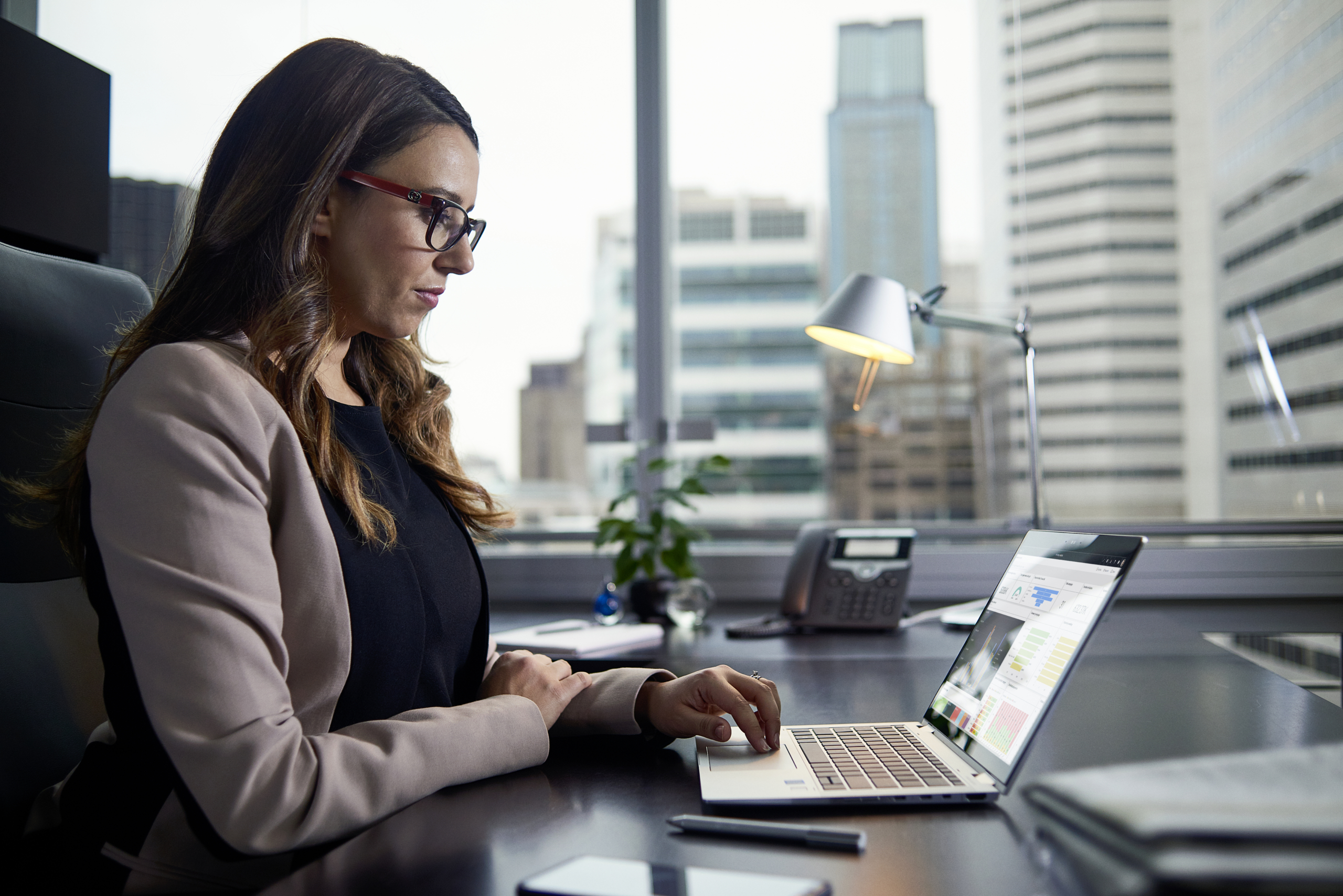 A woman sitting at a desk using a laptop