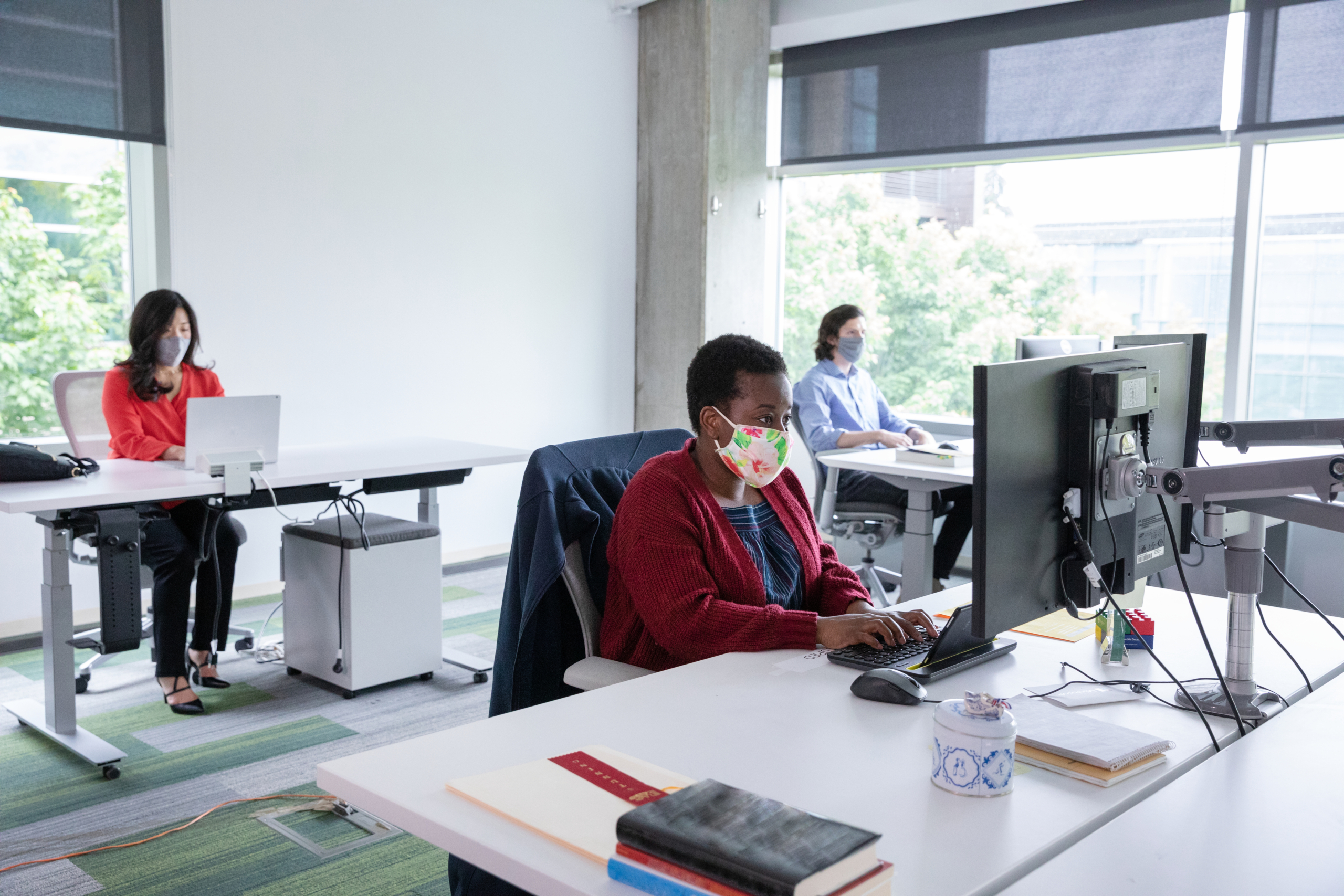 a person sitting at a desk in front of a window