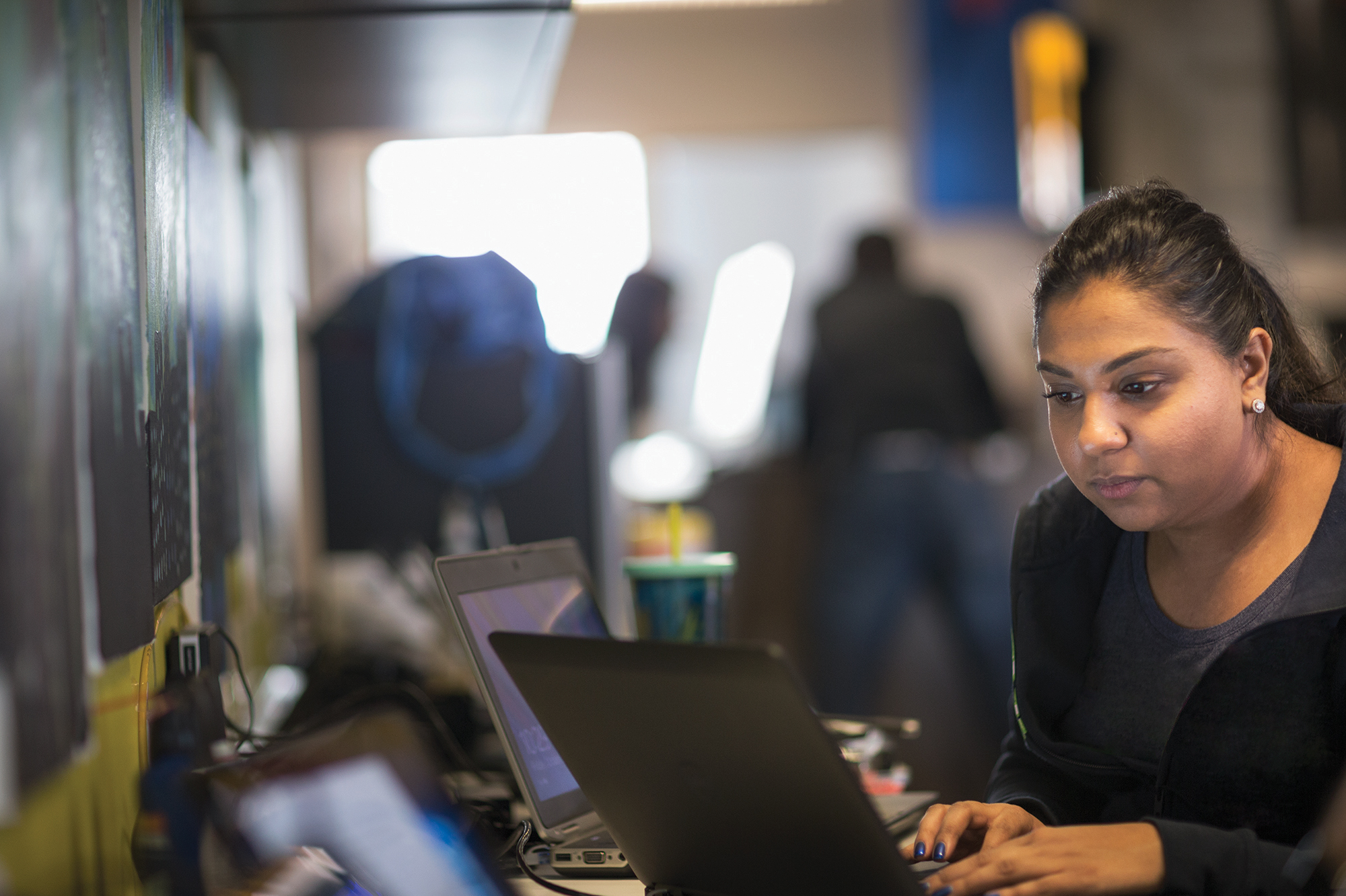 Woman at desk using two laptop computers