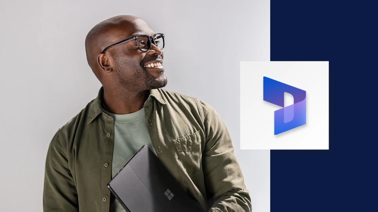 Portrait of smiling man carrying a Surface tablet. A wide, dark blue border runs down the right side of the image, overlaid with the Microsoft Dynamics 365 icon.