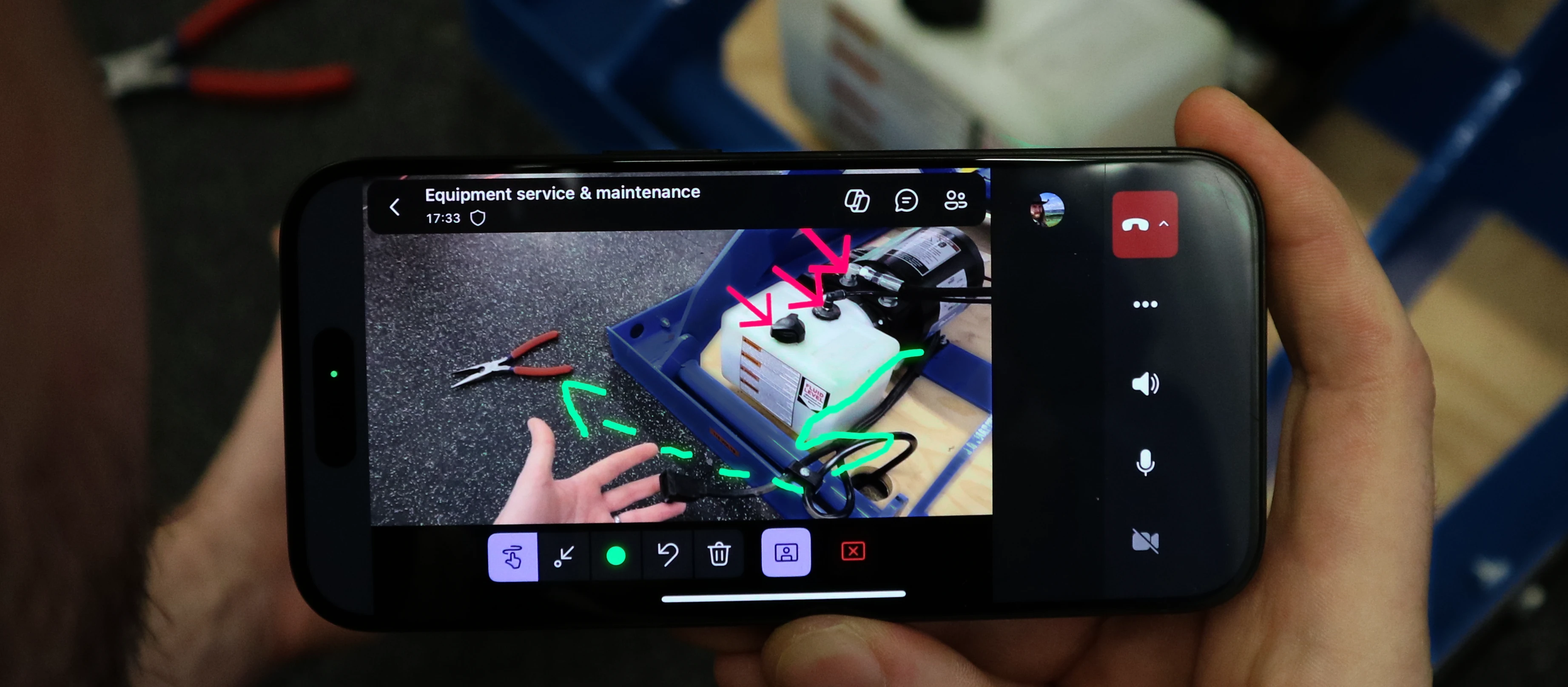 A hand holding a phone with a picture of a machine