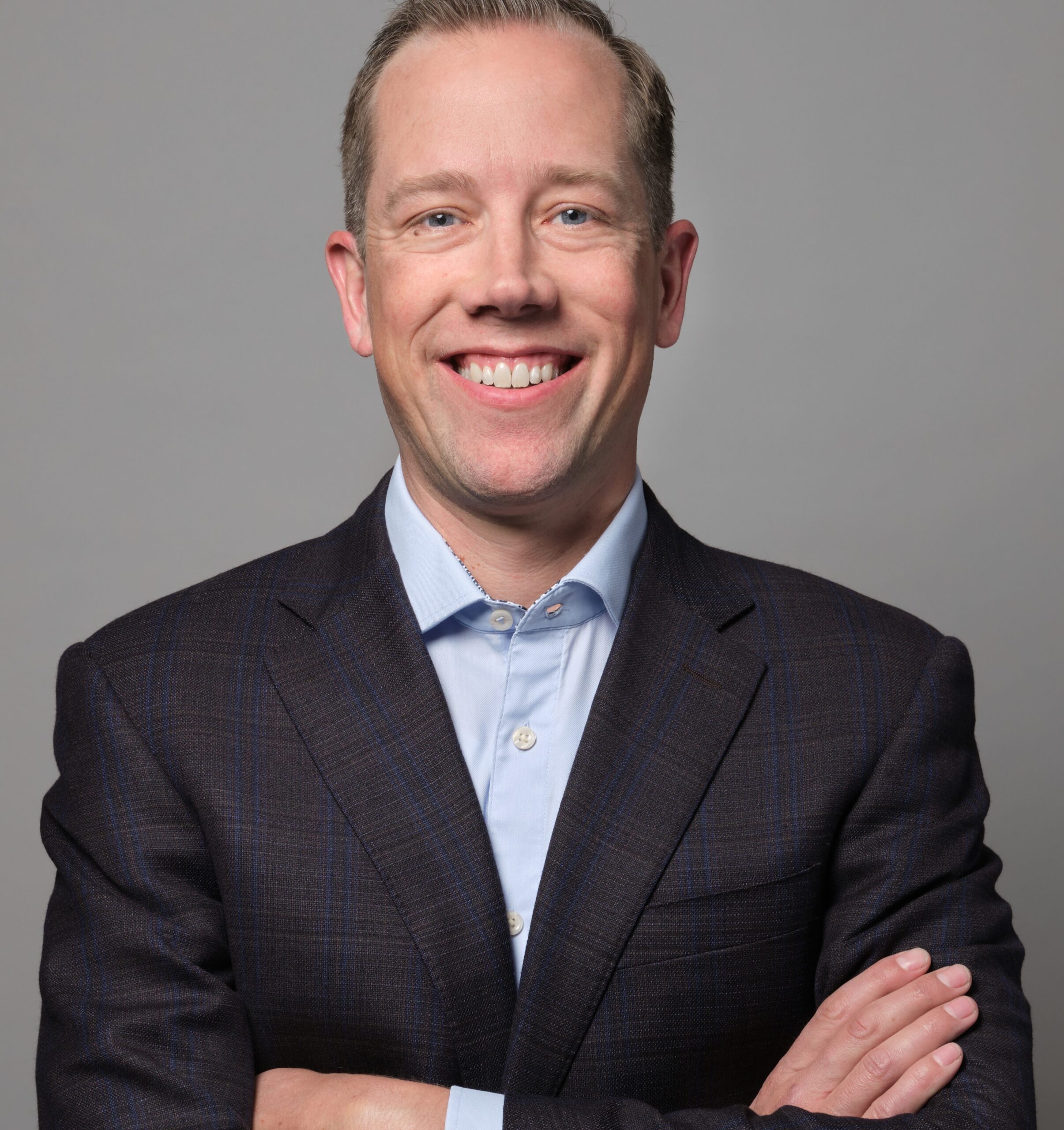 A man in a suit with his arms crossed