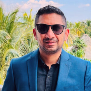 A man wearing sunglasses and a blue suit