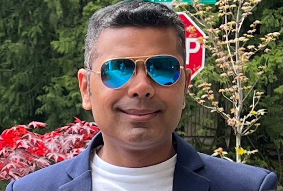 A man wearing sunglasses and smiling