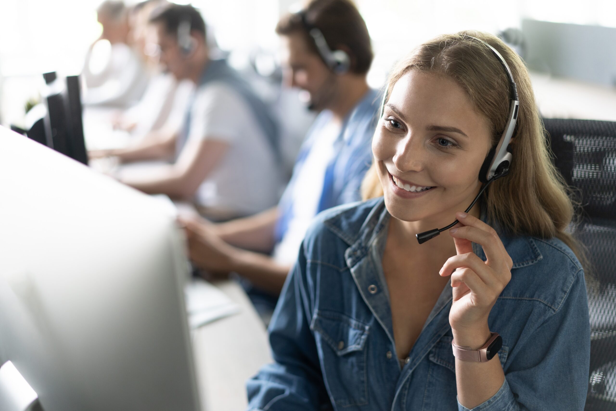 call center workers in headphones are working at modern office.