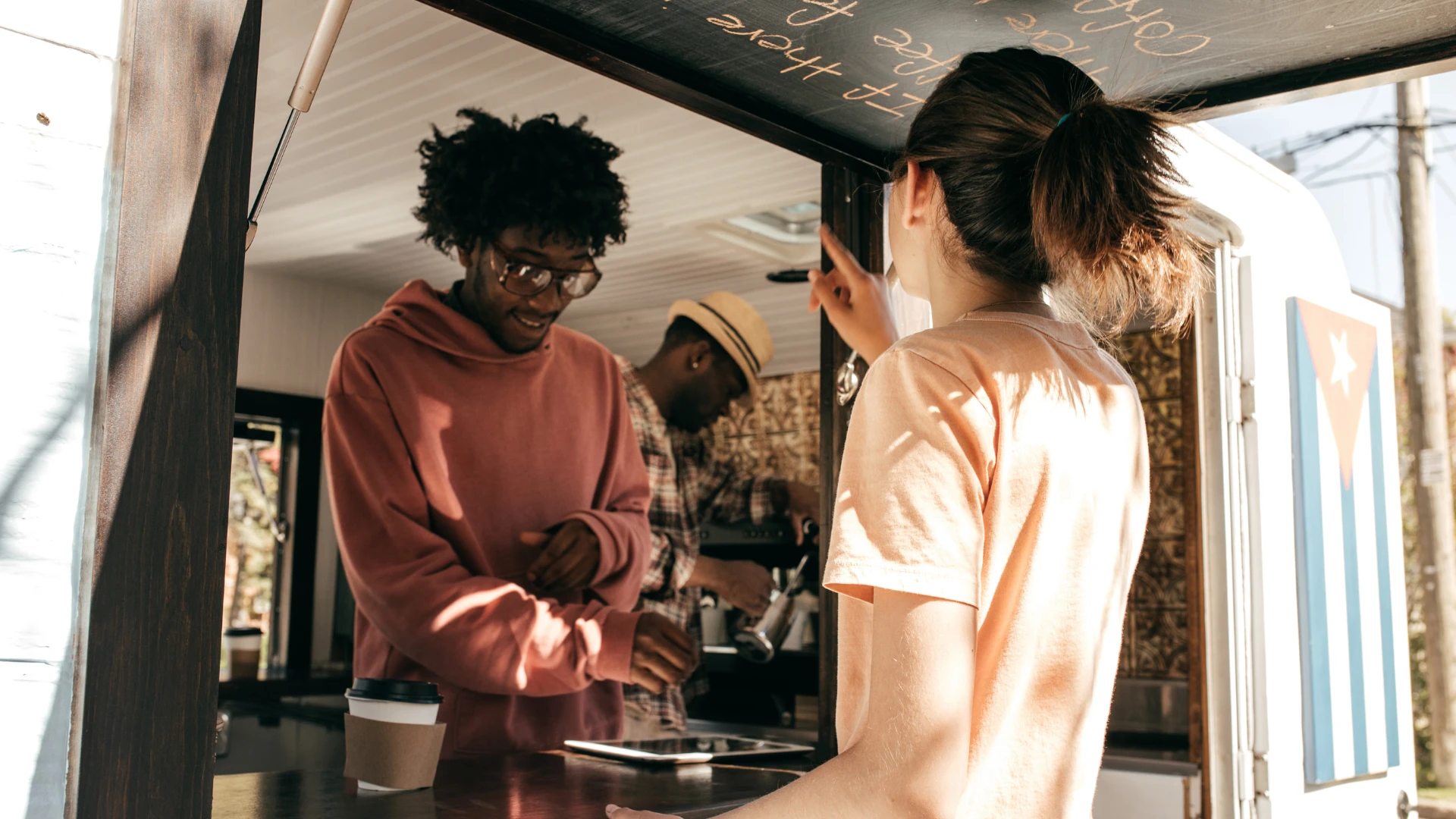 Customer interacting with a food truck point-of-sale system during an in-person ordering and purchase experience.