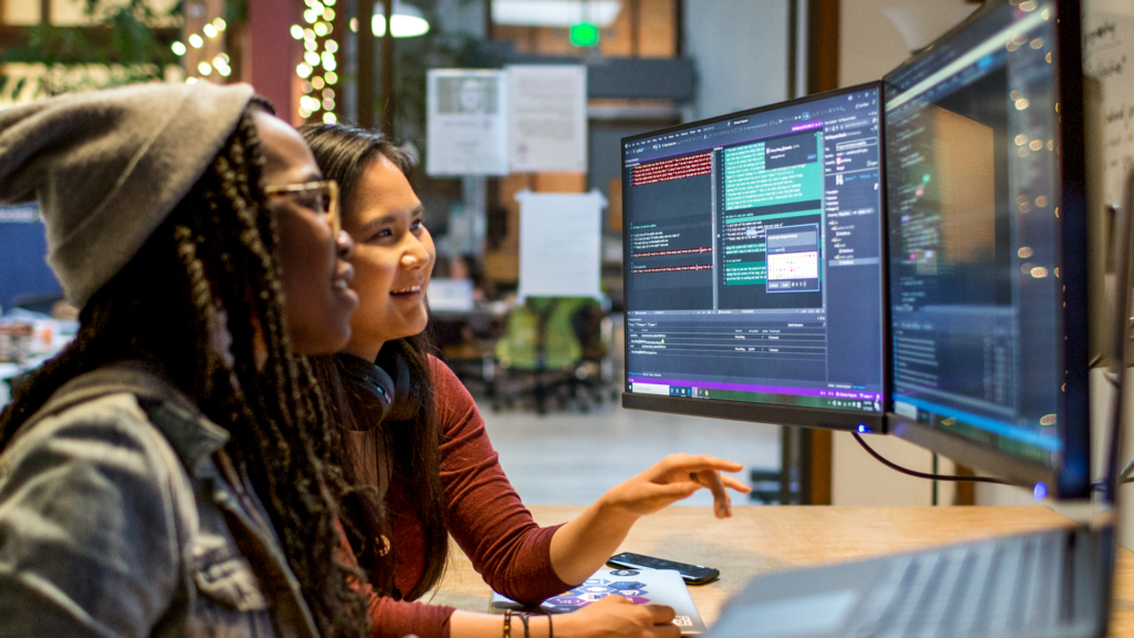 Two students working together on a computer.