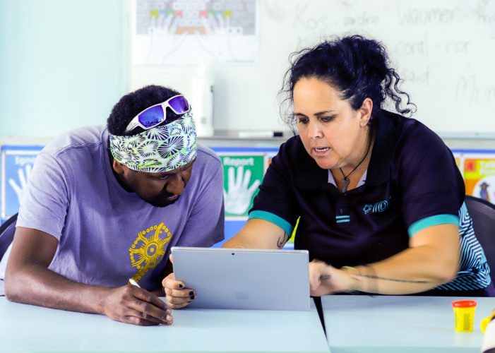 A woman and man work together on a laptop.