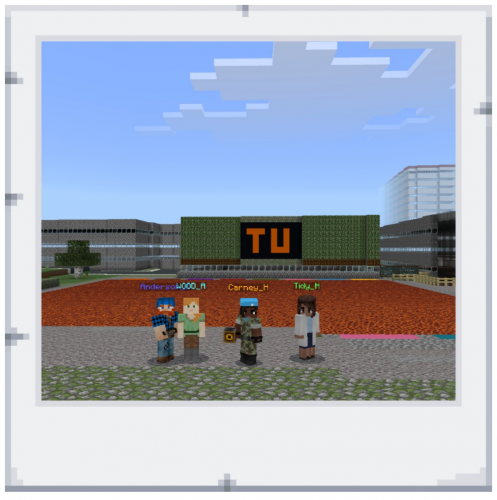 Four people stand in front of the Teesside University virtual campus in Minecraft: Education Edition