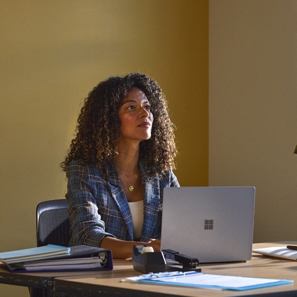 An education leader working at a desk in a school office.