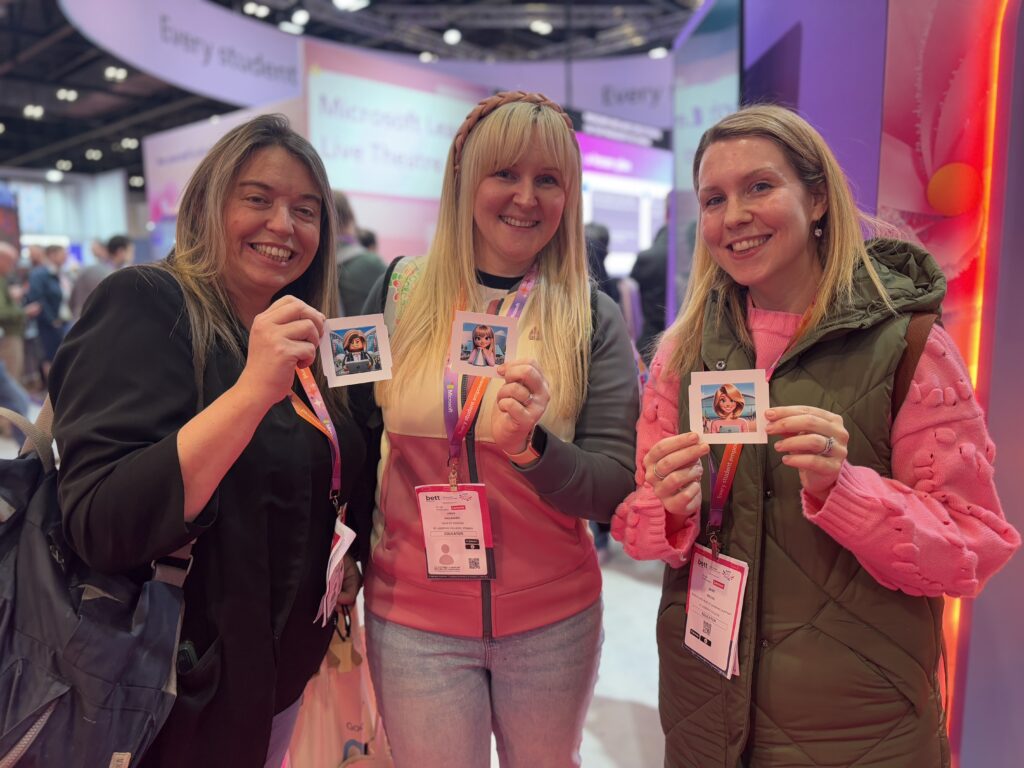Three conference attendees holding AI-generated images of themselves for the camera to see.