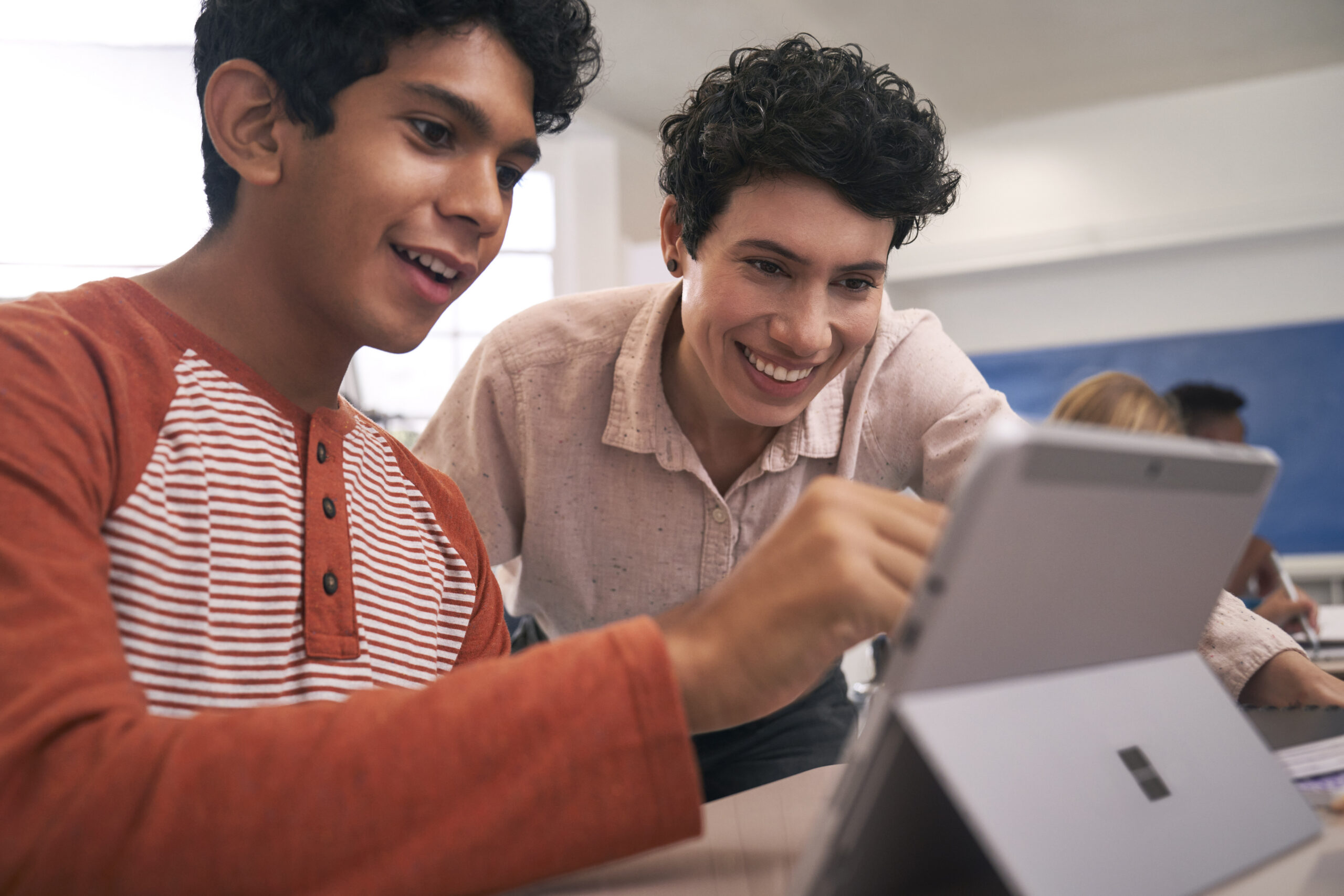 Teacher and student look at AI Agent on a tablet.