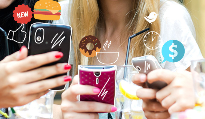 A couple of women huddled over mobile devices