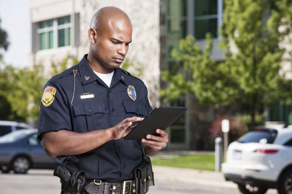 A police officer interacting with a touch screen device