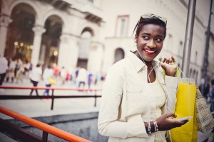 Young woman using device while shopping