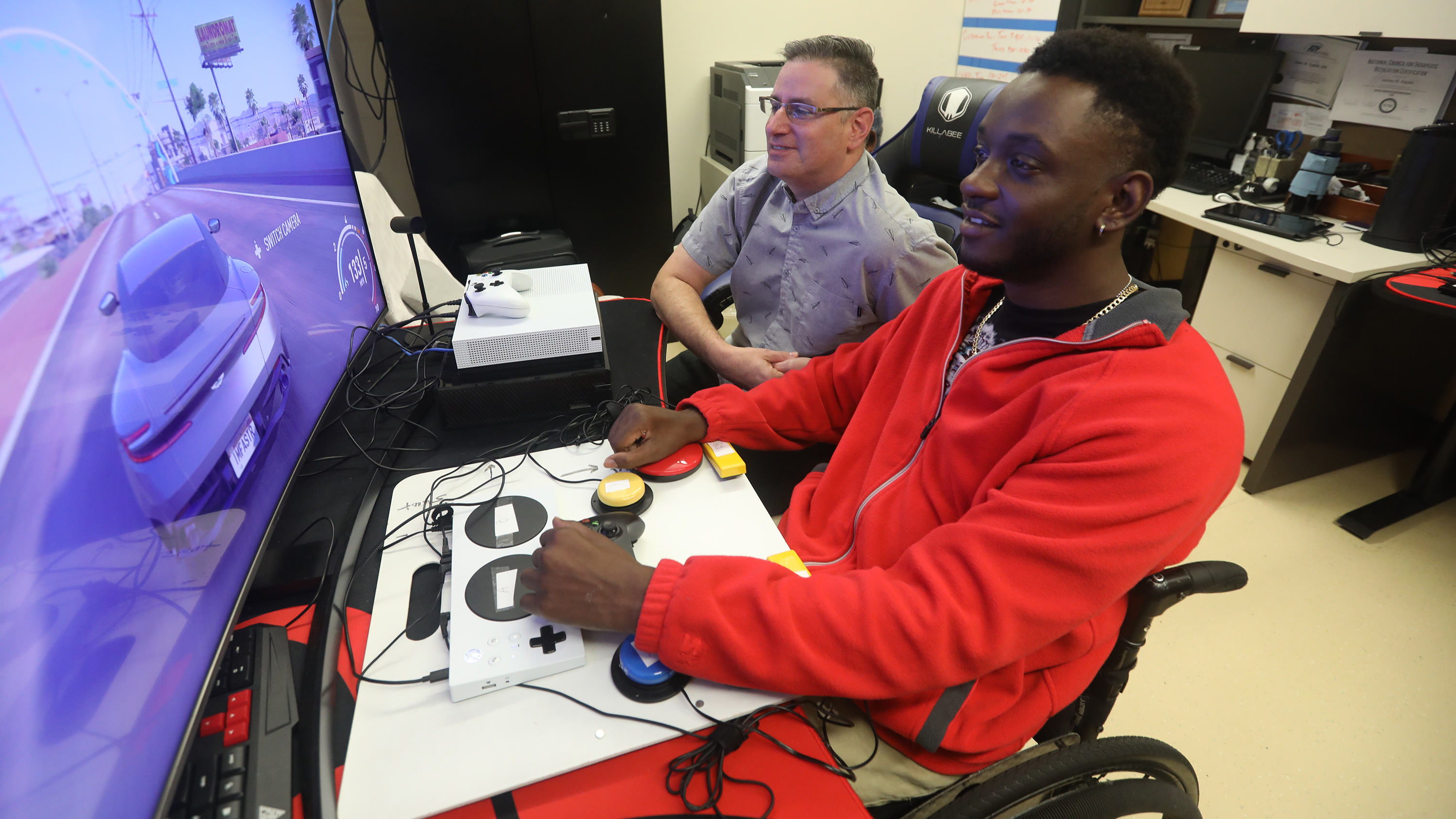 Man works with veteran with the XBOX Adaptive Controller