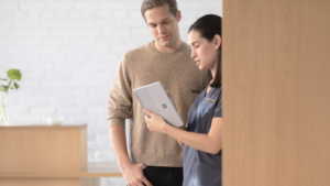 Nurse standing with a person standing in front of a building