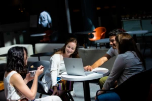 A group of tech industry employees chat in common area of U.S. office.