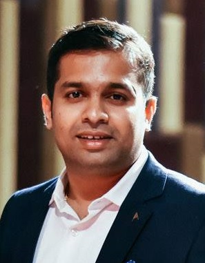 a man wearing a suit and tie smiling at the camera