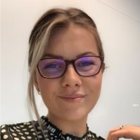 a woman wearing glasses and smiling at the camera