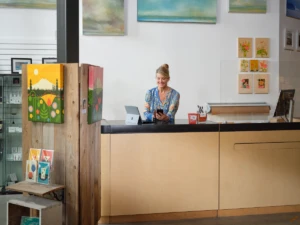 Retail shop owner working on Microsoft 365 Business Premium a mobile phone and a Surface.