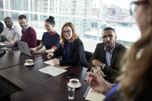 Female and male business professionals listening attentively to a presenter in a conference room