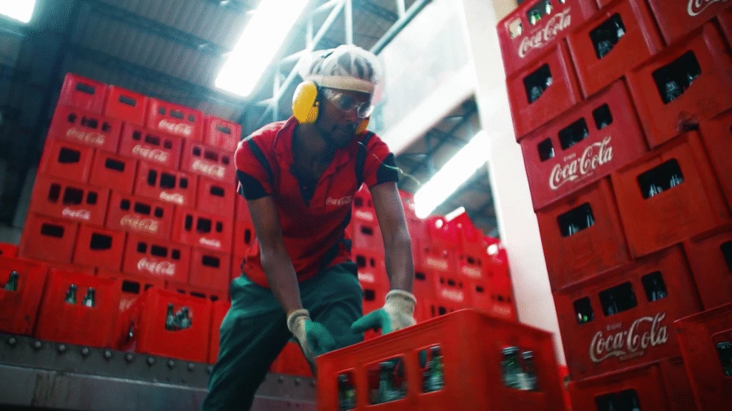 Coca-Cola Beverages Africa worker stocking bottles in a warehouse.