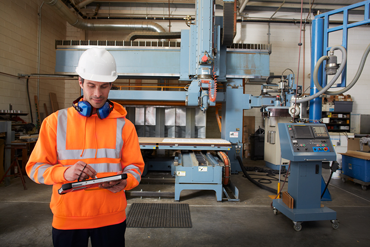 製造現場をタブレット端末で管理する男性
