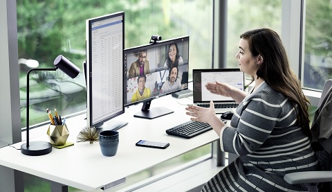 Eine Frau sitzt an einem Schreibtisch und arbeitet