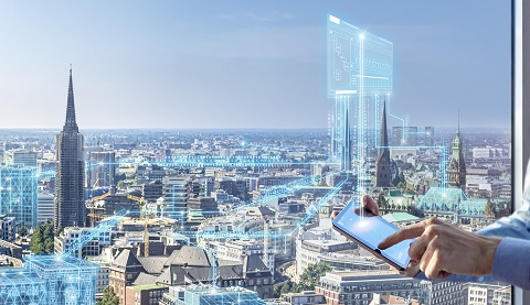 Blick auf eine Stadt mit mehreren Türmen und Wolkenkratzern. Auf dem Bild sieht man mehrere Hologramme. 