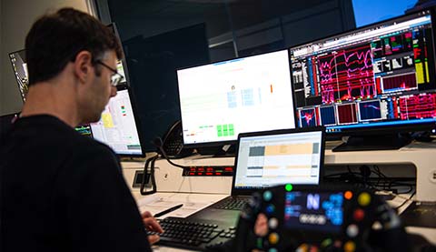 A male developer looking at several screens.