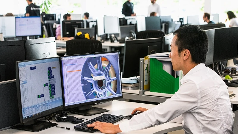 Ein Ingenieur arbeitet an seinem Schreibtisch im B&uuml;ro der Rennwagenfabrik.