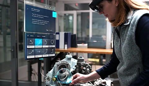 Frau mit einer Hololens2 arbeitet an einer Maschine.