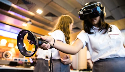 Eine junge Frau trägt eine Hololens und hält einen Holo-Griff.