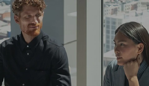 Mann und Frau in einem hohen Geb&auml;ude im Hintergrund ein Fenster. 