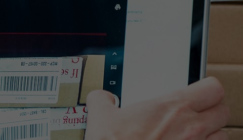 Eine Hand greift nach Paketen, die einen Strichcode tragen 