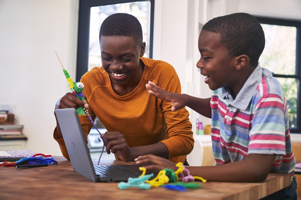 Zwei Kinder, die an einem Laptop spielen