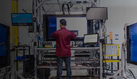 Ein Mann vor mehreren Bildschirmen