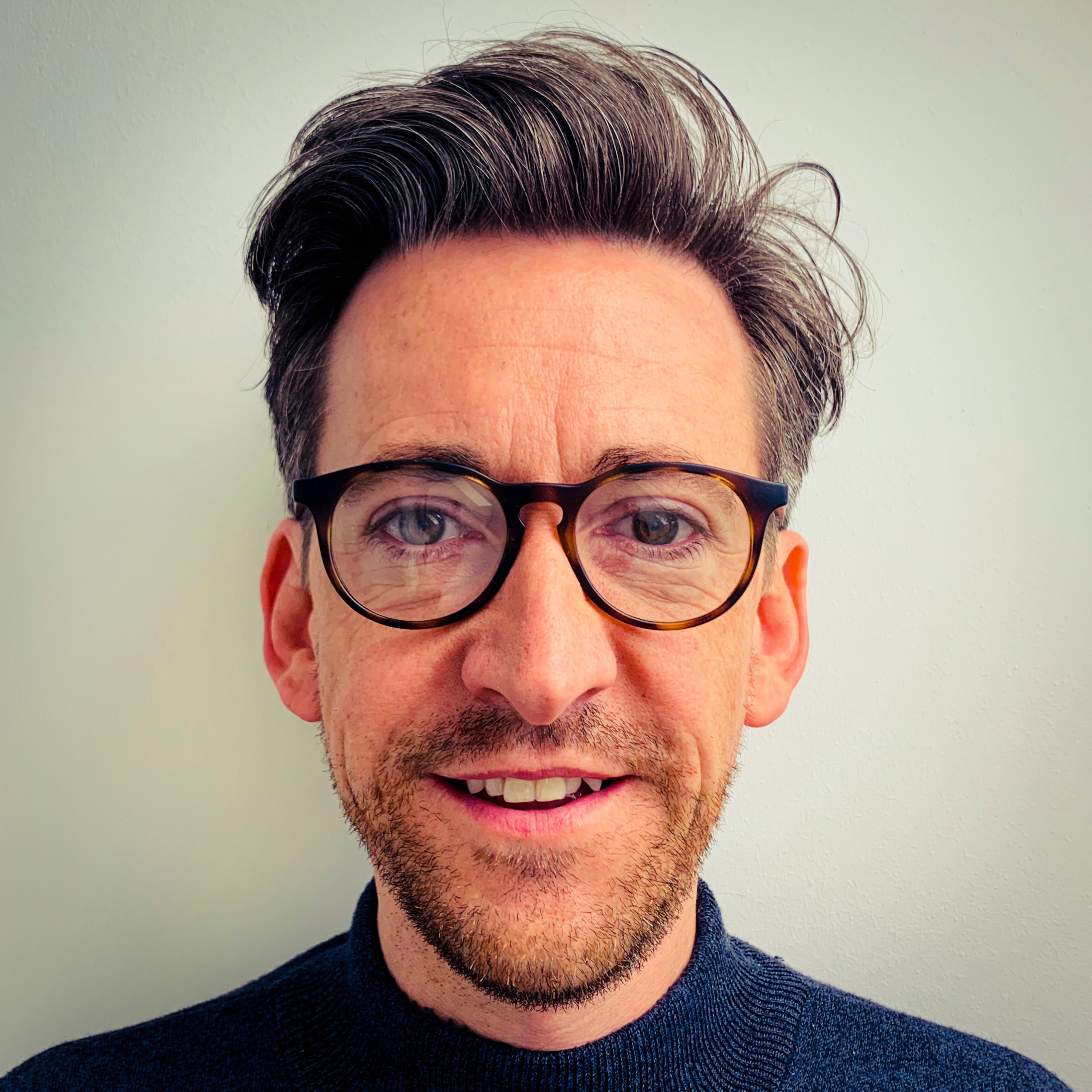 Stuart Almond wearing glasses and smiling at the camera